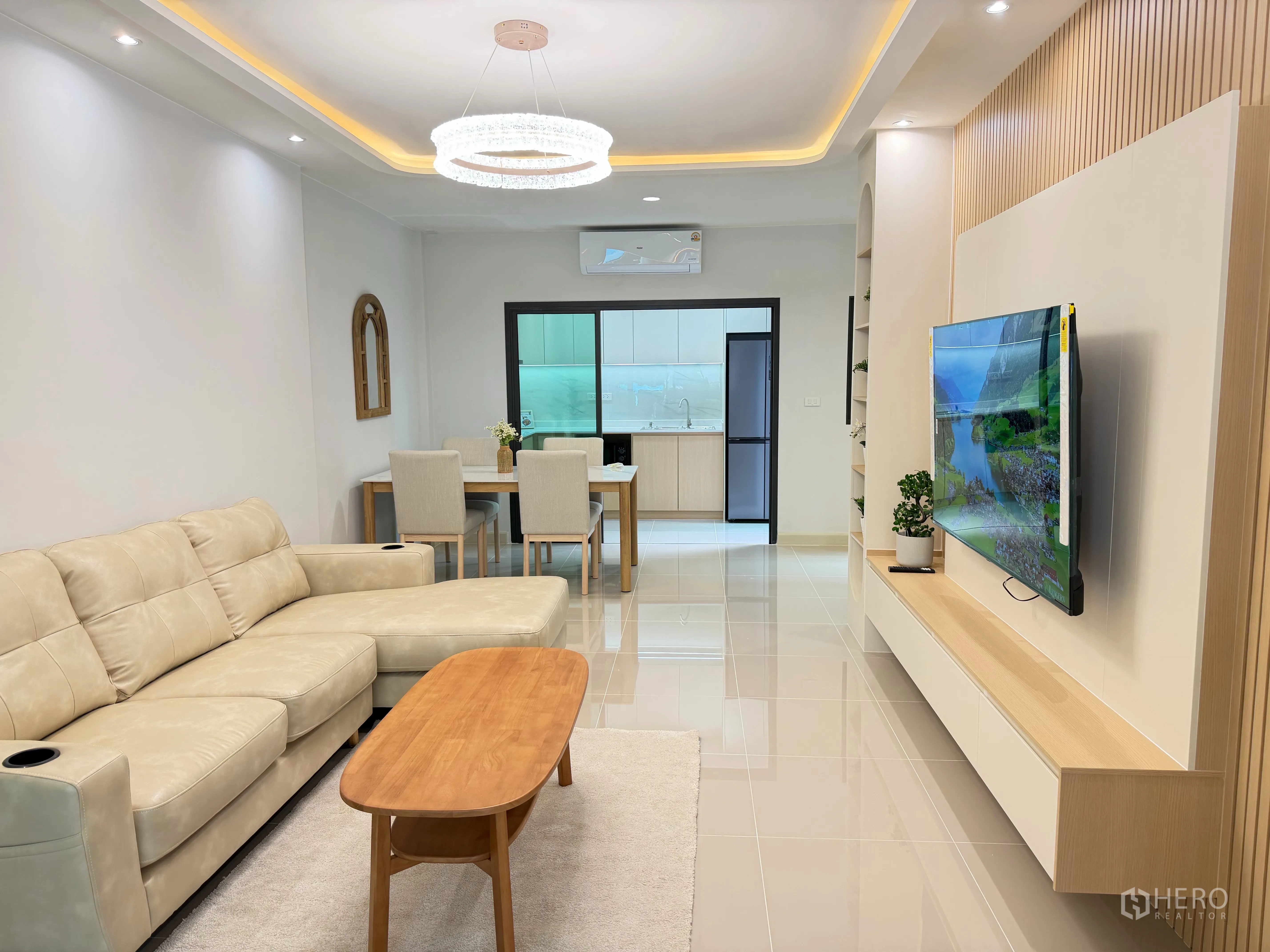 Townhouse for rent in Bang Phli, Samut Prakan - Open-plan living and dining area with sofa, TV, and view to the kitchen.