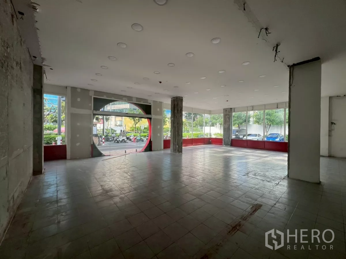 พื้นที่ขายปลีก ให้เช่า - พื้นที่กว้าง มองออกสู่ประตูทรงกลมและกระจกโอบรอบติดถนน