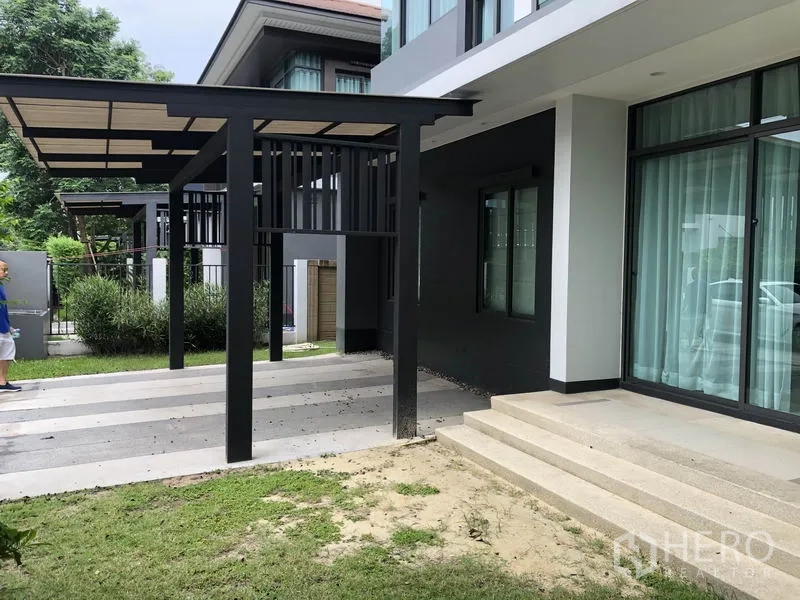 บ้าน ให้เช่าในBang Kapi, Bangkok - ภายนอกบ้านสไตล์โมเดิร์น โรงจอดรถมีหลังคา ขั้นบันไดสู่เฉลียงและสนามหญ้า