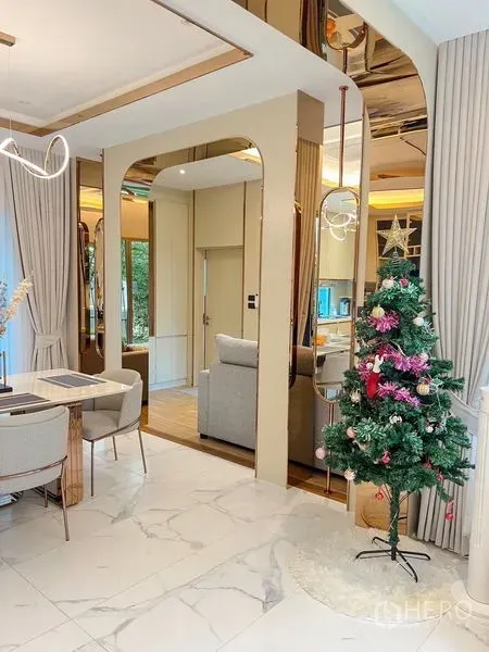 Detached House for sale in Bang Kapi, Bangkok - Arched doorway with gold accents, mirrors and marble floors connecting living spaces with seasonal decor.