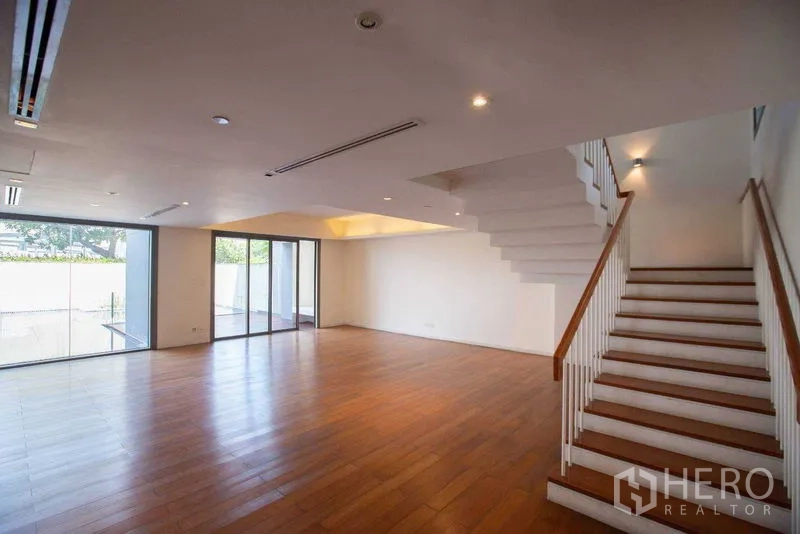 คอนโด ให้เช่าในYan Nawa, Bangkok - ห้องนั่งเล่นโล่งกว้างพร้อมบันได และประตูกระจกเปิดสู่ลานสระส่วนตัว