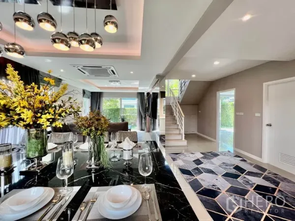 บ้าน ขายในBang Sao Thong, Samut Prakan - พื้นที่รับประทานอาหารและนั่งเล่นแบบโอเพ่น พร้อมโต๊ะหินอ่อน โคมไฟระย้า และบันได ในบ้านเดี่ยวรีโนเวทใหม่ย่านลาดกระบัง กรุงเทพฯ