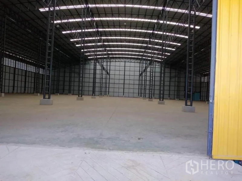 工厂 出租在Mueang Samut Prakan, Samut Prakan - 从入口处看到黄色推拉大门与明亮的高挑屋架。