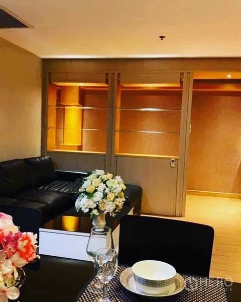 公寓 出租在Watthana, Bangkok - 餐桌视角望向客厅，内置层架与滑门相连。