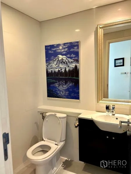 คอนโด ให้เช่า - ห้องน้ำแขกขนาดกะทัดรัด ผนังสีขาว โถสุขภัณฑ์ อ่างล้างหน้า และภาพวิวภูเขา