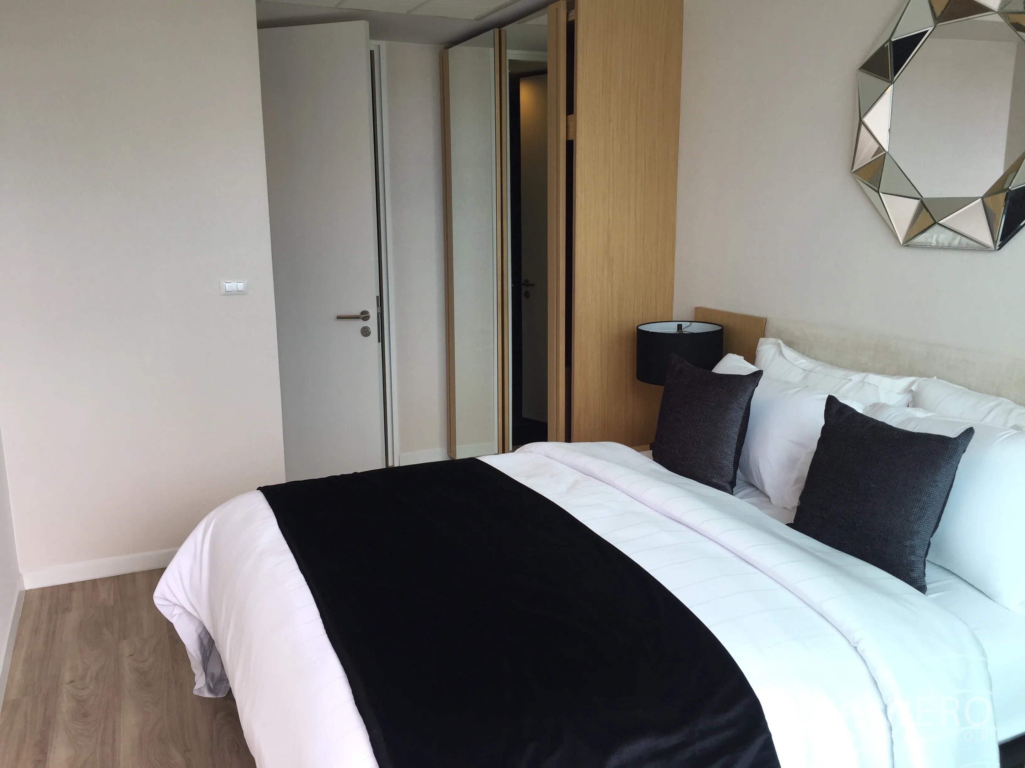 公寓 出售在Bang Rak, Bangkok - 第二卧室，木地板与内置衣柜，简约中性色调。