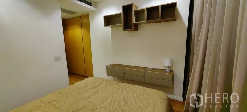 คอนโด ให้เช่าในKhlong San, Bangkok - ผนังห้องนอนติดชั้นวางของและลิ้นชักลอย ใกล้ผ้าม่านโปร่ง