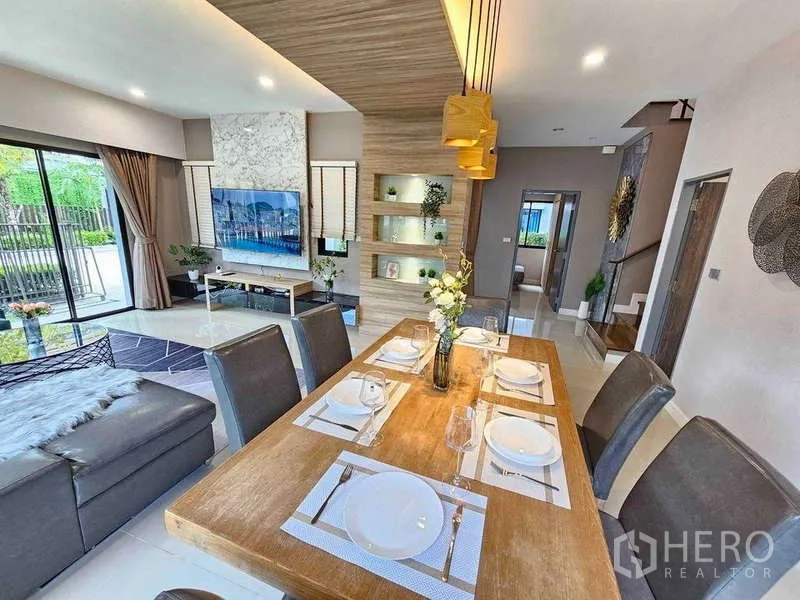 独立式住宅 出租在Prawet, Bangkok - 木质氛围餐厅，现代吊灯可眺望花园