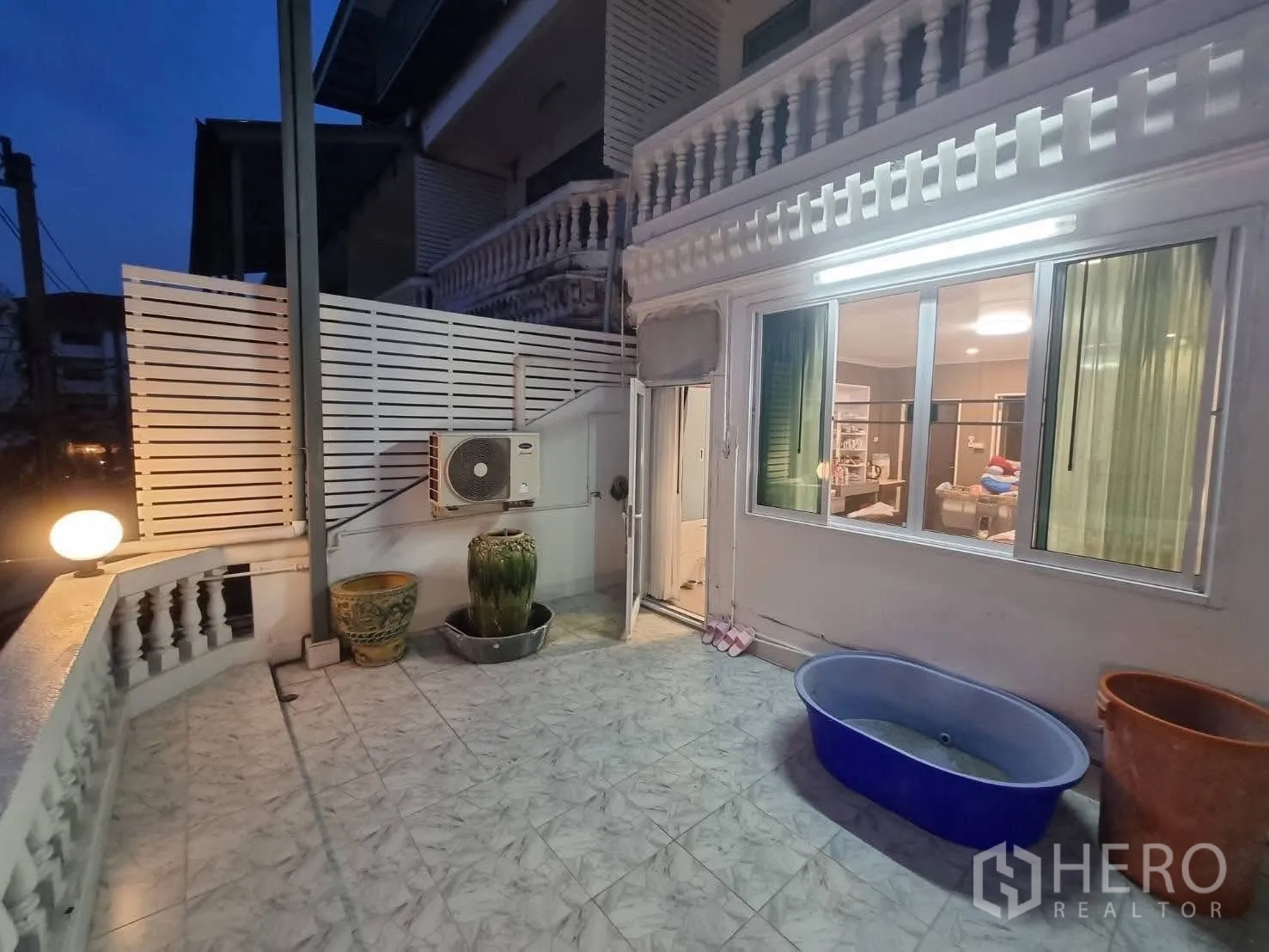 Townhouse for rent in Din Daeng, Bangkok - Tiled front terrace with balustrade, wall lights and sliding windows.