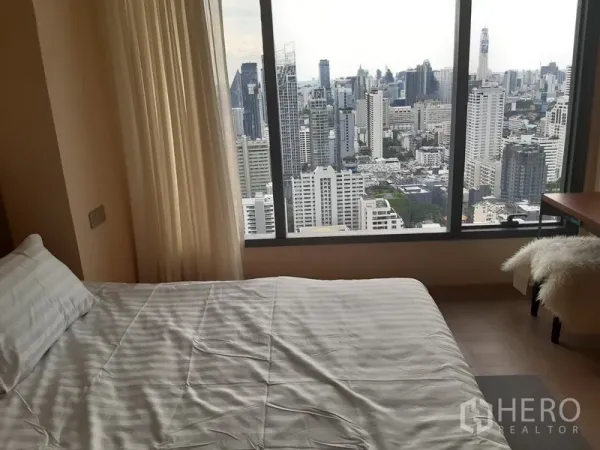 公寓 出租或出售在Watthana, Bangkok - 卧室配大床与落地窗，享受壮观城市景观。