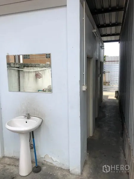 Warehouse for rent in Don Mueang, Bangkok - Simple staff restroom block with wall-mounted sink beside the warehouse.