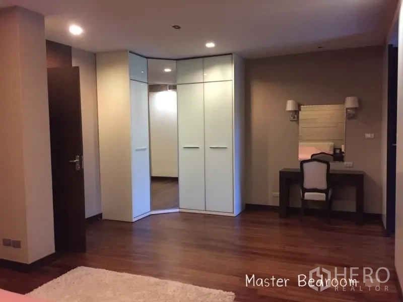 公寓 出租在Sathon, Bangkok - 主卧套间，转角衣柜、梳妆台与木地板。