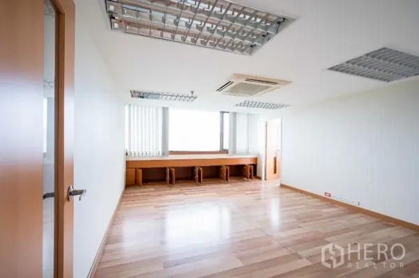 办公空间 出租在Pathum Wan, Bangkok - 宽敞办公间，浅色木地板，窗下长条内置工作台，天花式空调。