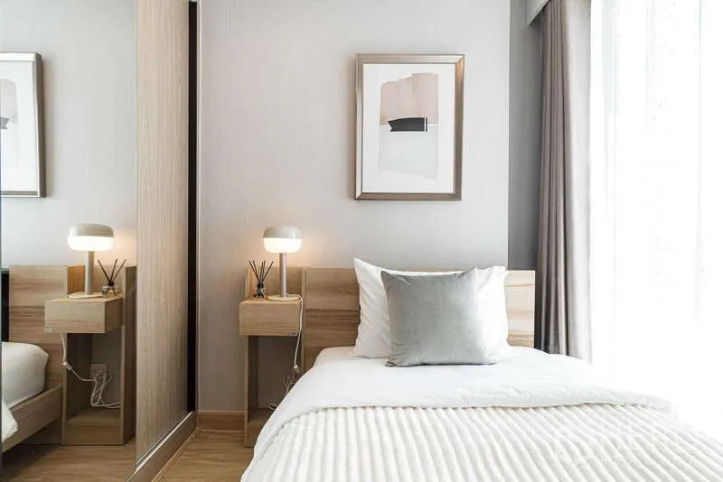 คอนโด ให้เช่า - มุมห้องนอนพร้อมไฟตั้งสองข้างและตู้เสื้อผ้าบานกระจก