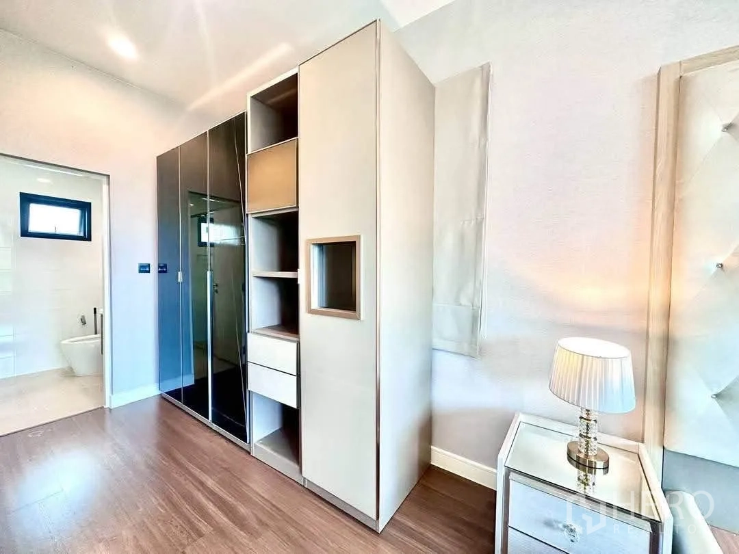 Detached House for rent in Bang Kapi, Bangkok - Bedroom corner with wardrobes, nightstand and view into ensuite bathroom.