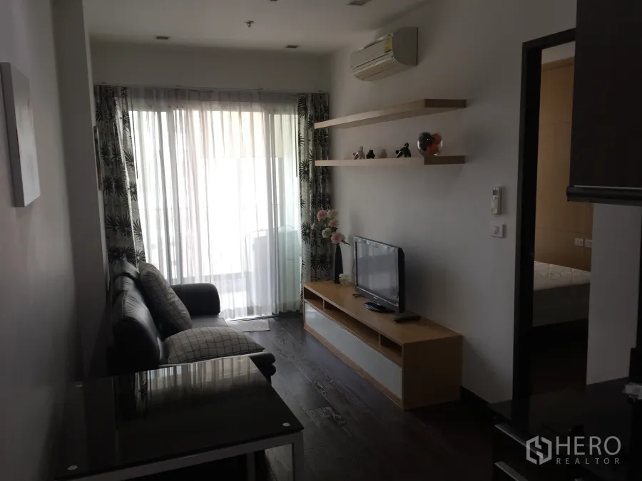 คอนโด ให้เช่าในRatchathewi, Bangkok - ห้องนั่งเล่นสว่าง โปร่งด้วยประตูกระจกบานเลื่อน ม่านโปร่ง โซฟา และชั้นวางทีวี ในคอนโดสไตล์โมเดิร์น