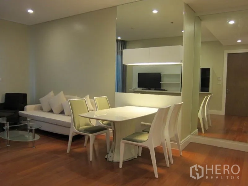 คอนโด ให้เช่าในKhlong Toei, Bangkok - พื้นที่นั่งเล่นและรับประทานอาหารแบบเปิดในคอนโดย่านสุขุมวิท โต๊ะสีขาว โซฟา ผนังกระจก และพื้นไม้โทนอุ่น