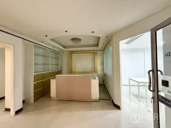 办公空间 出租在Din Daeng, Bangkok - 接待区，带前台与内置玻璃柜，玻璃门与浅色装饰。