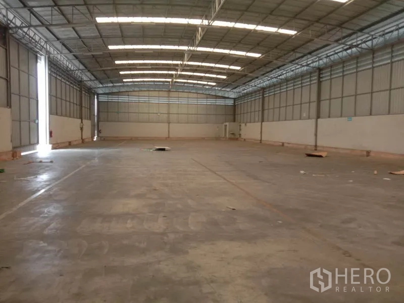 货栈 出租在Lat Krabang, Bangkok - 长条形仓库大厅，高挑顶与自然采光板，地面为混凝土。