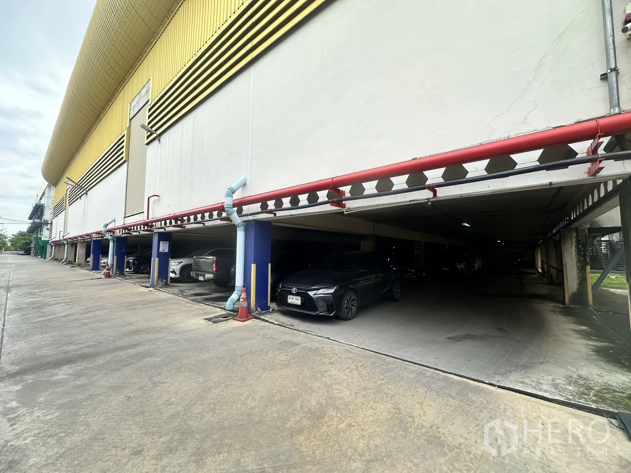 Warehouse for rent in Lat Krabang, Bangkok - Covered parking area along the exterior with multiple car spaces.