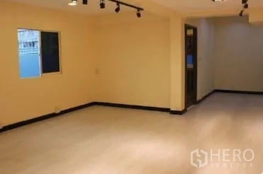 办公空间 出租在Bang Rak, Bangkok - 开放式办公区，浅色地板、轨道射灯、小窗与通往内室的门。