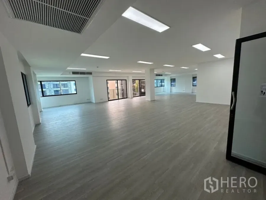 Office Space for rent - Spacious office floor with ducted air-conditioning vent, glass entry door, wide windows and open layout near BTS Surasak.