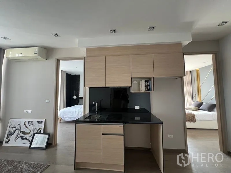 คอนโด ขาย - ครัวขนาดกะทัดรัดท็อปสีดำและตู้บิลท์อิน คั่นระหว่างสองห้องนอน