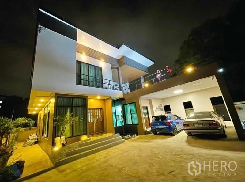 บ้าน ขายในSai Mai, Bangkok - บ้านเดี่ยวสองชั้นสไตล์โมเดิร์นยามค่ำ พร้อมไฟส่องสว่างและที่จอดรถมีหลังคา