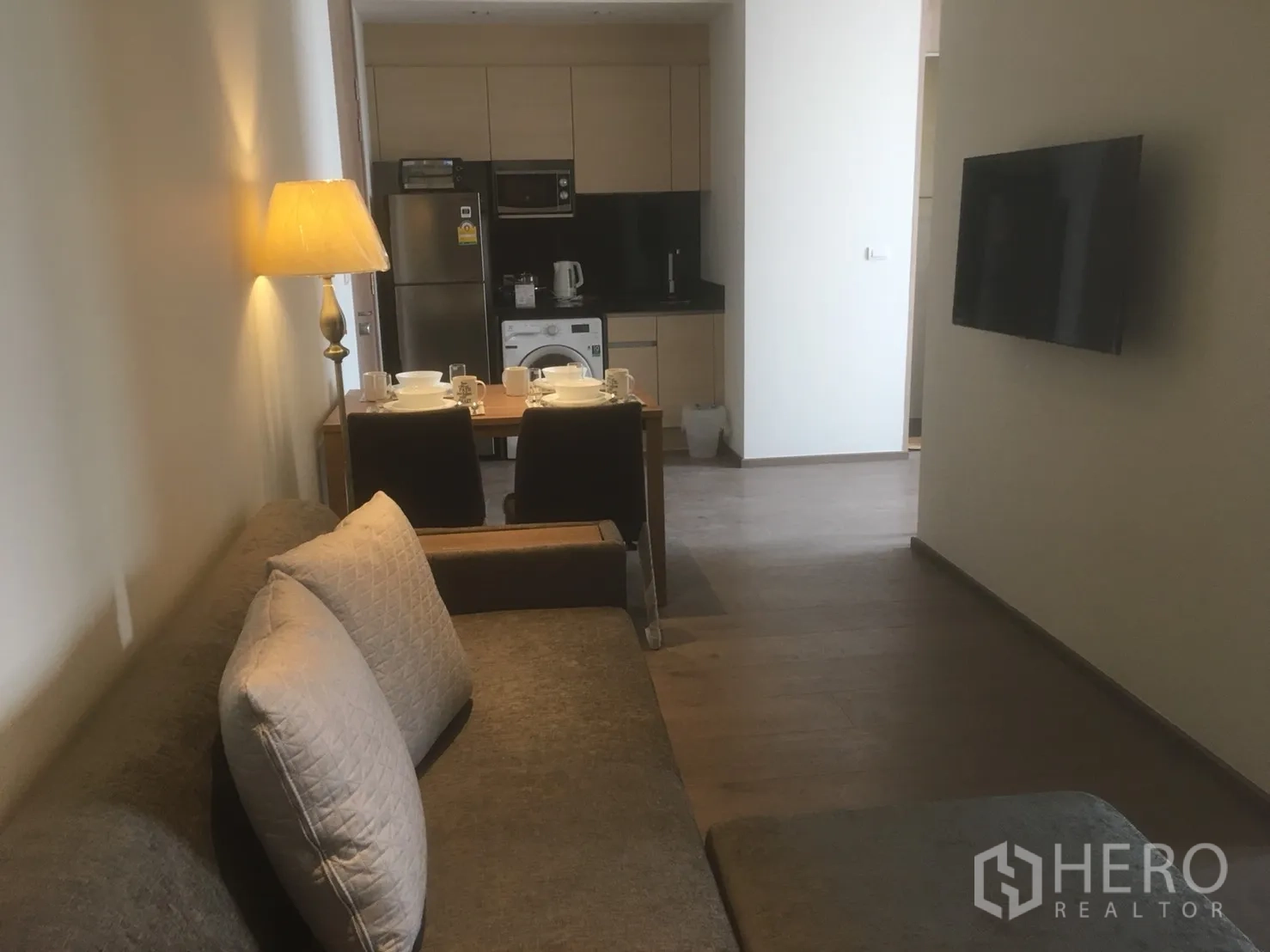 公寓 出租或出售在Khlong Toei, Bangkok - 开放式客餐厅，沙发、壁挂电视与通往厨房的用餐区