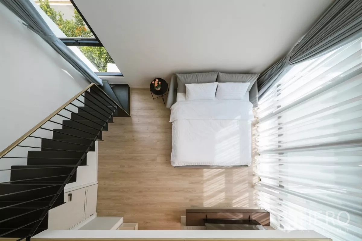 บ้าน ให้เช่าหรือขายในSaphan Sung, Bangkok - มุมมองจากด้านบนของห้องนอนเพดานสูง เตียงข้างผ้าม่านยาวและบันได