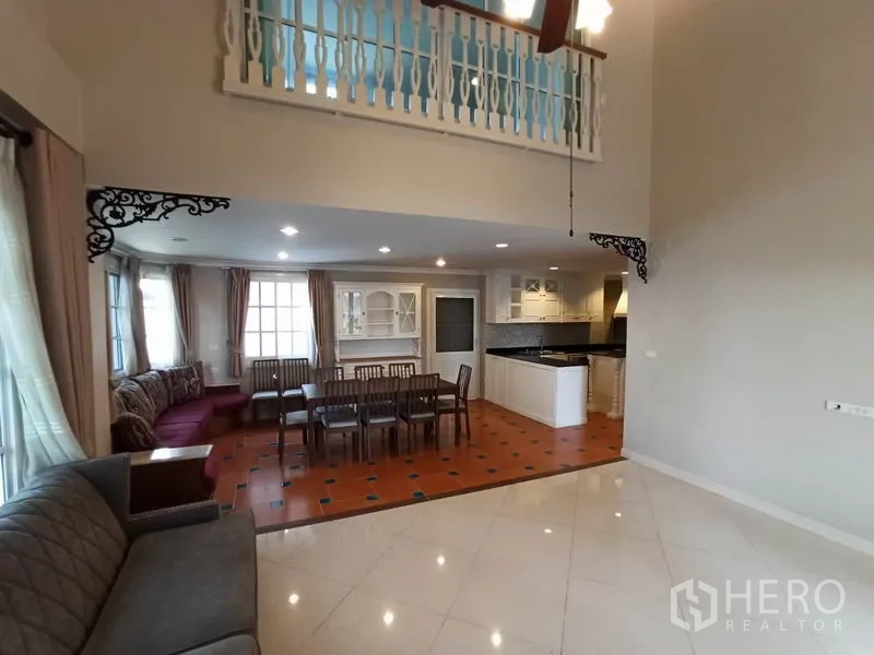 独立式住宅 出租在Mueang Samut Prakan, Samut Prakan - 开放式客餐厅连接厨房，赤陶地砖与楼中楼护栏。