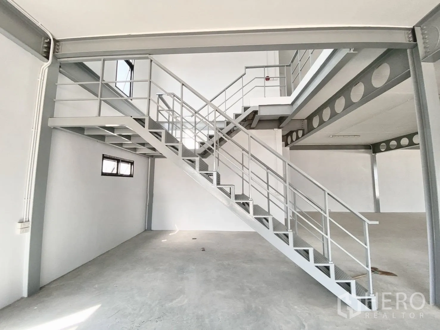 Warehouse for rent in Bang Bo, Samut Prakan - Mezzanine office area with metal staircase and guard rails inside the warehouse.