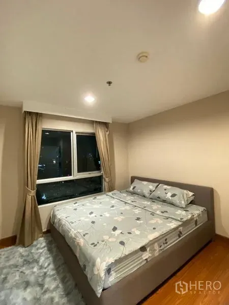 Condominium for rent - Bright bedroom with large window, curtains, and double bed overlooking city lights.