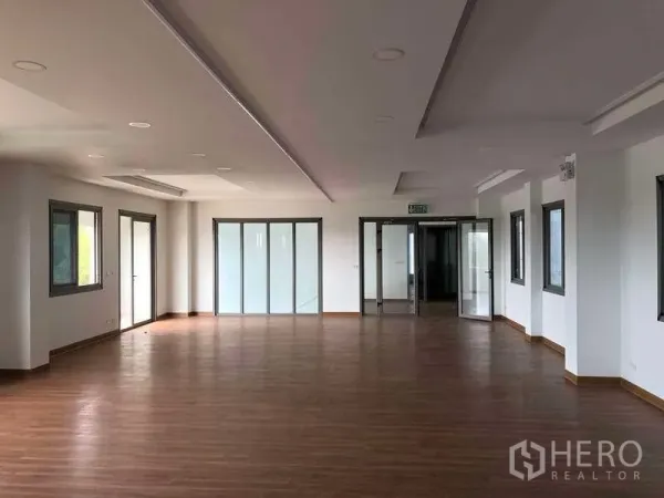 工厂 出租或出售在Samut Prakan - 明亮的开放式办公室，木地板与多扇玻璃门窗。