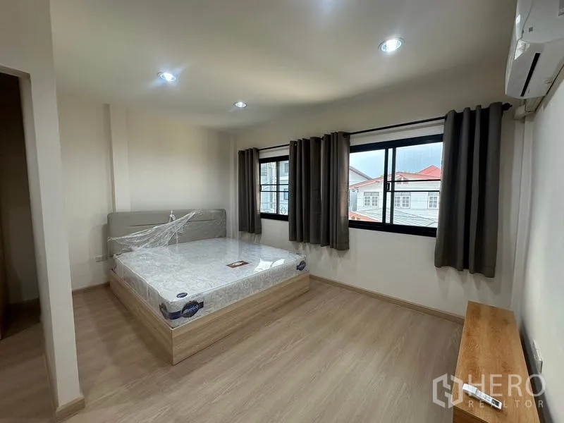 ทาวน์เฮาส์ ให้เช่าหรือขายในPhra Khanong, Bangkok - ห้องนอนสว่าง เตียงวางติดหน้าต่างสองบาน พร้อมผ้าม่านทึบ