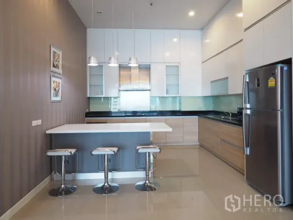 Condominium for rent in Ratchathewi, Bangkok - Contemporary kitchen with island, bar stools, glossy cabinetry and stainless refrigerator.