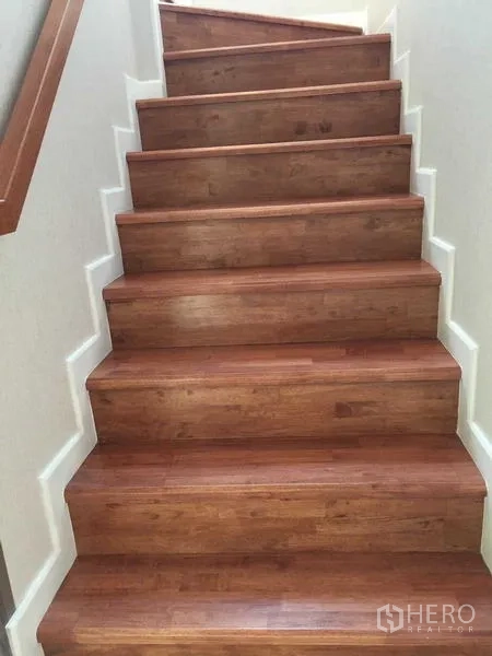 Townhouse for sale in Bang Khae, Bangkok - Close-up of wooden staircase with white skirting leading upstairs.