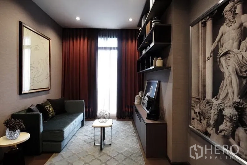 公寓 出租在Bang Rak, Bangkok - 雅致起居区，沙发与壁柜一体，装饰画与柔和灯光面向高窗。