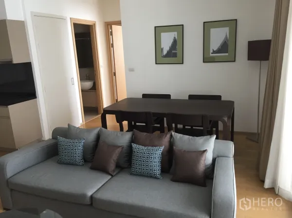 公寓 出租或出售在Watthana, Bangkok - 用餐区，深色木餐桌四椅，墙面装饰画，旁边连通卫生间。