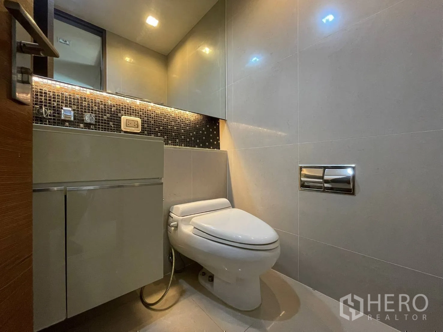 Condominium for rent or sale in Bang Rak, Bangkok - Modern bathroom with mosaic backsplash, vanity cabinet and toilet.