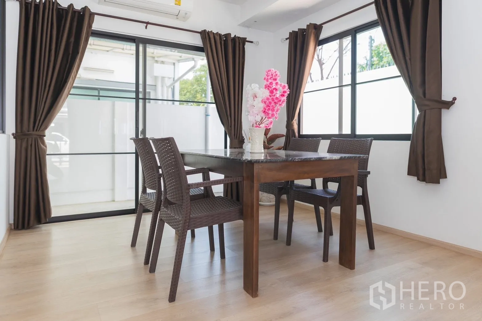 Townhouse for rent in Bang Phli, Samut Prakan - Dining corner with sliding glass doors and brown curtains.