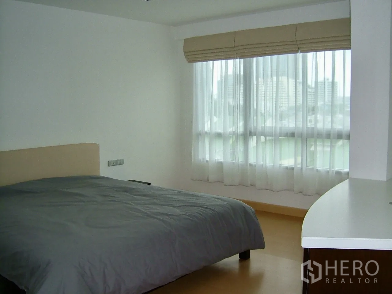 Condominium for rent or sale in Khlong Toei, Bangkok - Master bedroom with large window, sheer curtains, city view and king bed.