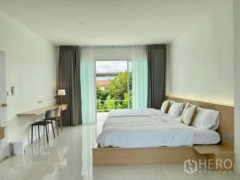 บ้าน ให้เช่าในLat Krabang, Bangkok - ห้องนอนสว่าง เตียงคู่ ผ้าม่านสูงจรดเพดาน พร้อมระเบียงวิวต้นไม้