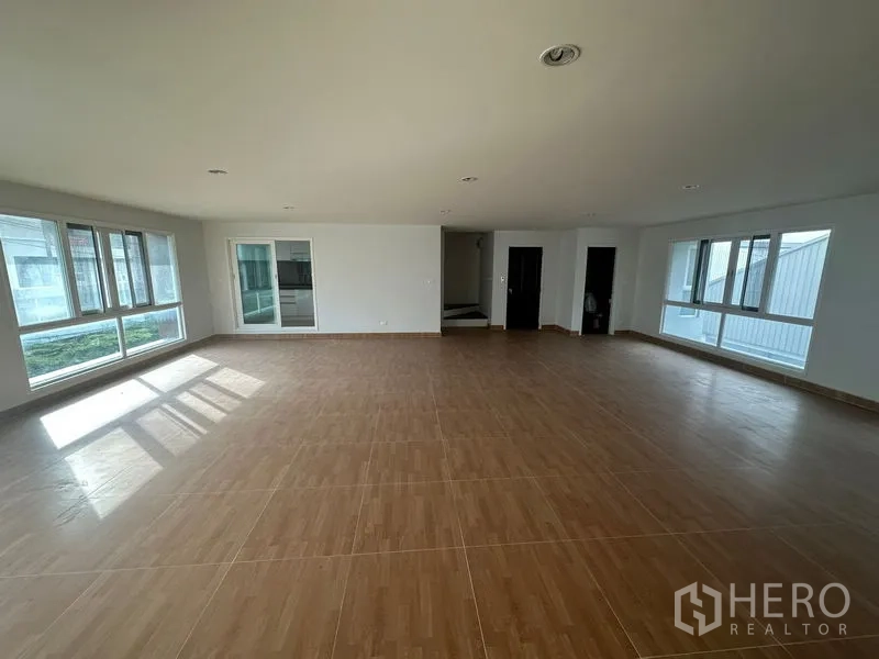 Home Office for rent in Bang Phli, Samut Prakan - Open-plan room with wood-look tiles, multiple doorways and windows.