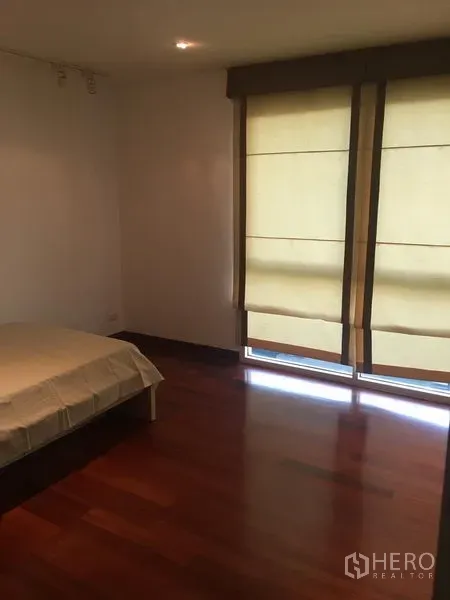Condominium for rent or sale in Watthana, Bangkok - Guest bedroom with floor-to-ceiling blinds, wood flooring and soft natural light.