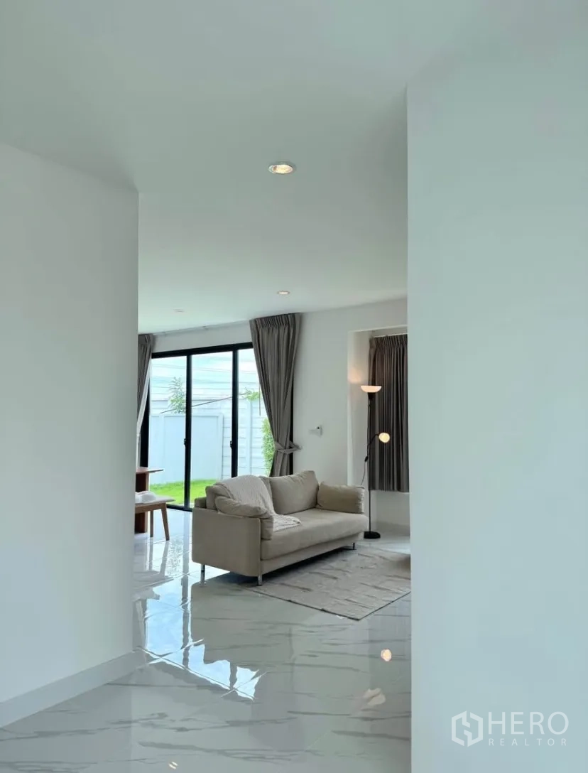 Detached House for rent in Samut Prakan - Entrance hallway leading to a bright lounge with sliding doors to the garden.