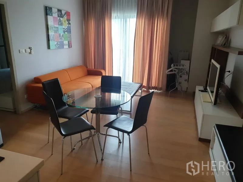 คอนโด ให้เช่าในWatthana, Bangkok - มุมนั่งเล่นและทานอาหารสว่าง โซฟาสีส้ม โต๊ะกระจก และม่านสูงจรดเพดานในคอนโดเอกมัย