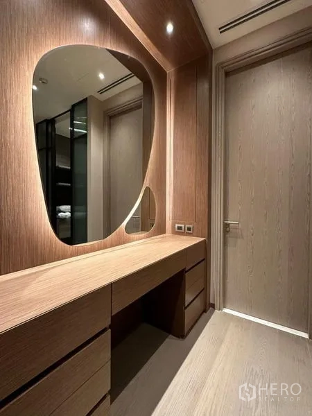 Condominium for rent or sale - Warm wood dressing area with built‑in vanity and organic-shaped mirrors.