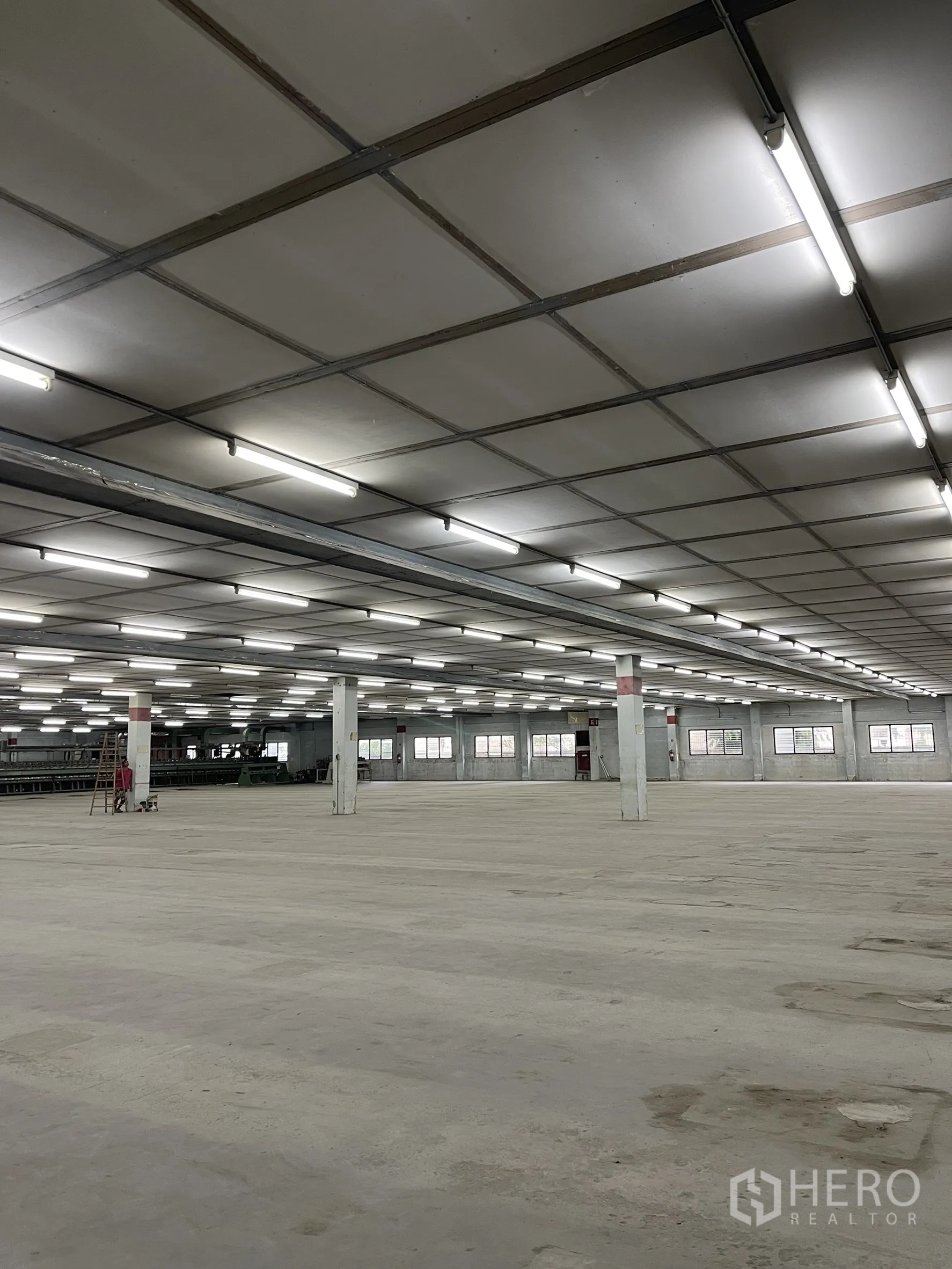 工厂 出租在Phra Samut Chedi, Samut Prakan - 宽敞的工厂内部，网格天花与明亮日光灯，大片混凝土地面。