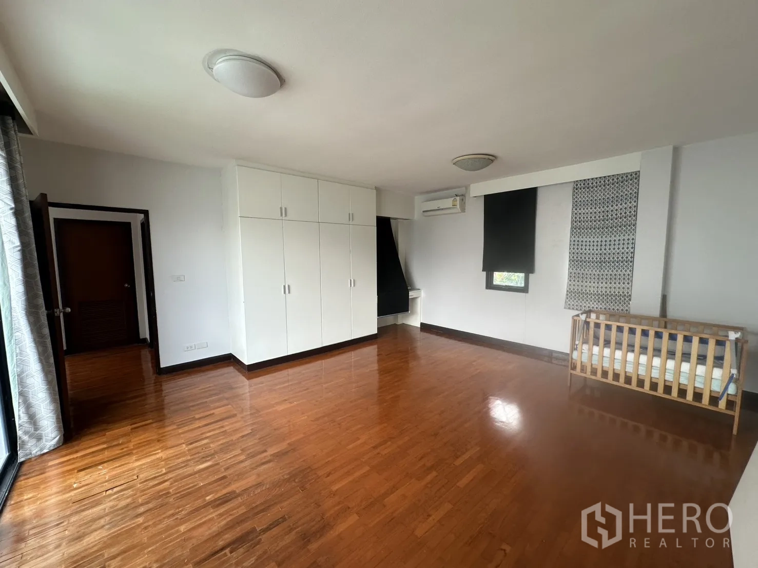 独栋房屋 for rent in Watthana, Bangkok - 卧室内置白色衣柜、木地板与婴儿床